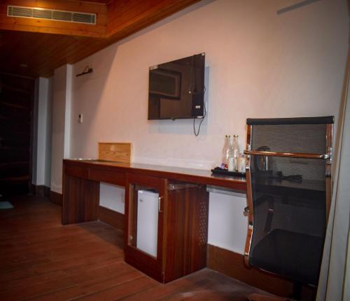 a kitchen with a counter and a tv on the wall at Oro Montana Hotels and Resort in Gangtok
