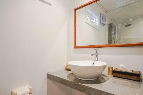 a bathroom with a white bowl sink on a counter at Wayan Homestay Sanur in Sanur