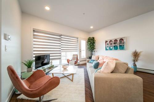 a living room with a couch and a tv at Steamy Romantic Greek Corneer Suite King U/G Wifi in Edmonton
