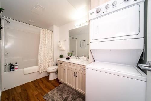 a white bathroom with a sink and a toilet at Steamy Romantic Greek Corneer Suite King U/G Wifi in Edmonton