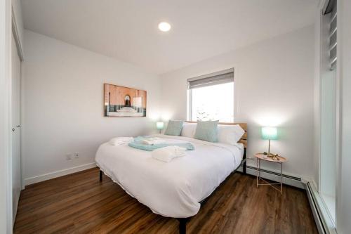 a large white bed in a room with a window at Steamy Romantic Greek Corneer Suite King U/G Wifi in Edmonton