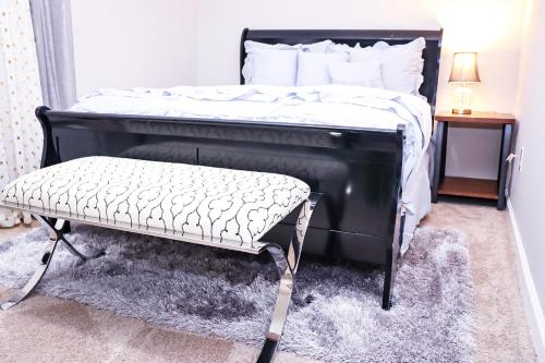 a black bed with a bench in a bedroom at Luxury 2BR 1bt Suite basement Vacation House Private Entrance in Lithonia