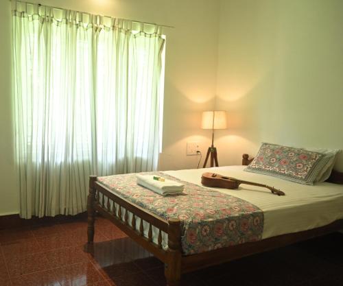 Un dormitorio con una cama con una lámpara y una ventana. en Pool Villa - The Humming Trees, Pala, en Lālam