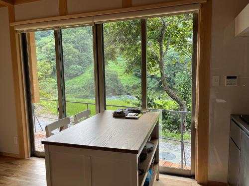 eine Küche mit einem großen Fenster mit Blick auf einen Baum in der Unterkunft CrossFit Otoyo Strength TINY HOUSE in Otoyocho