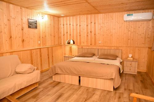 - une chambre avec 2 lits dans une pièce en bois dans l'établissement Hayi Tun Guest House, à Goris