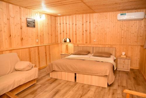 a bedroom with two beds in a wooden room at Hayi Tun Guest House in Goris