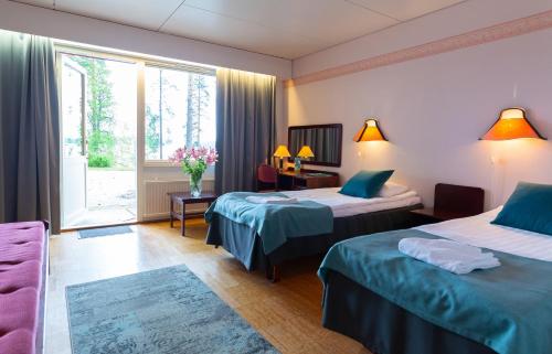um quarto de hotel com duas camas e uma janela em Hotelli Keurusselkä em Keuruu