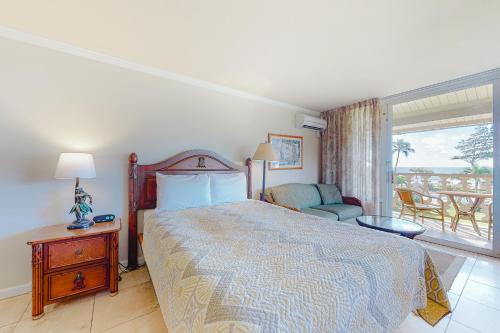 a bedroom with a bed and a view of the ocean at Islander on the Beach 304 in Kapaa
