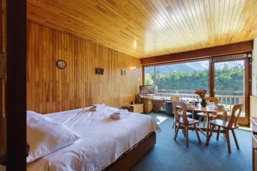 a bedroom with a bed and a table with chairs at Résidence Grands Montets 221 ski in-ski out - Happy Rentals in Chamonix