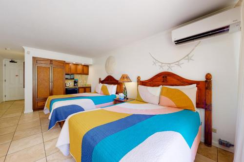 a bedroom with two beds with colorful blankets at Islander on the Beach 170 in Kapaa