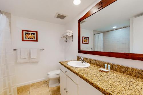 a bathroom with a sink and a toilet and a mirror at Islander on the Beach 170 in Kapaa