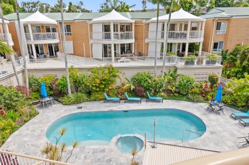 an image of a swimming pool in front of a building at Serenity Apartments Noosa in Noosa Heads