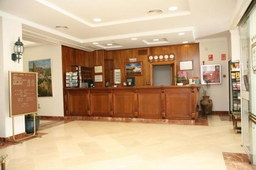 a lobby with wooden cabinets and a cash register at Hotel Peña de Arcos in Arcos de la Frontera