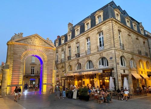 grupa ludzi siedzących przed budynkiem w obiekcie Hôtel Madame w mieście Bordeaux