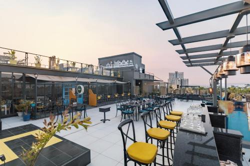 Horizon Hotel في أودايبور: فناء على السطح مع طاولات وكراسي ومسبح