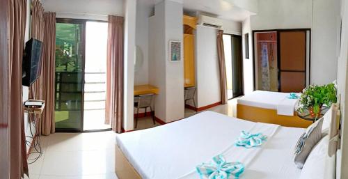 a hotel room with two beds and a balcony at Heart Hotel and Services in Dumaguete