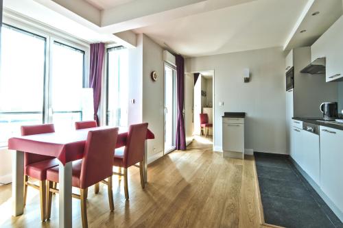 une cuisine et une salle à manger avec une table et des chaises dans l'établissement Résidence Quai Sud-Le Bourdonnais, à Saint-Malo