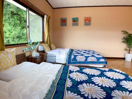 2 camas en una habitación con 2 ventanas en Villa235, en Shirahama