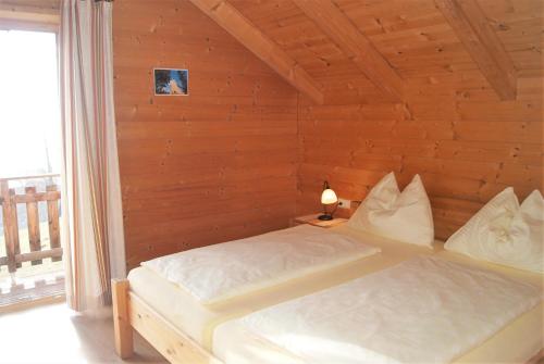 a bedroom with a bed in a wooden wall at Ferienhaus mit Panoramaausblick und Sauna - 3 SZ in Pöllauberg