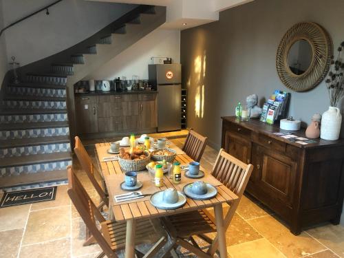 a dining room with a table and chairs and a staircase at Le Mas Justin in Gordes