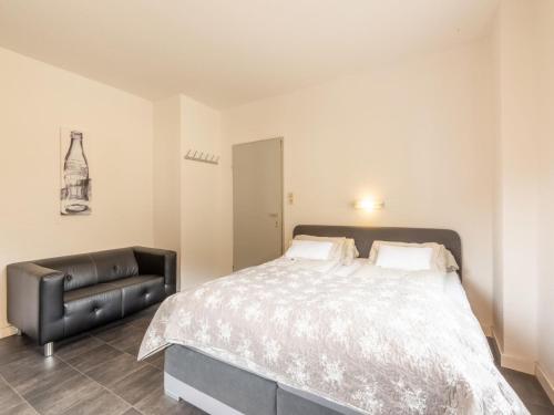 a bedroom with a bed and a black leather chair at Apartment in Bichlbach near Ski Slopes in Bichlbach