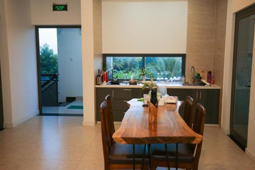 a kitchen with a wooden table and some chairs at Aroma Garden Suites Hoi An in Hoi An