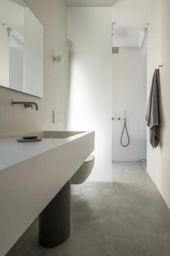 a white bathroom with a sink and a toilet at Aesthesis Boutique Villa Trace in Fira
