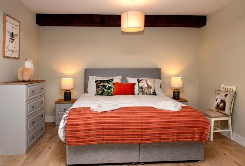 a bedroom with a large bed with red pillows at K2Cottages 