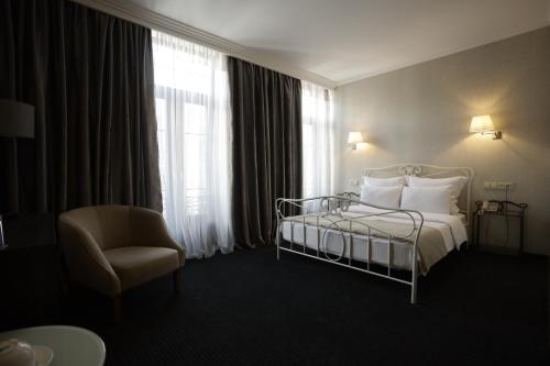 فندق ريدلاين  في تبليسي: غرفة نوم بسرير وكرسي ونافذة