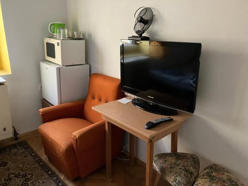 a television sitting on a table next to a chair at Belvárosi minilakás 2 főre in Pécs