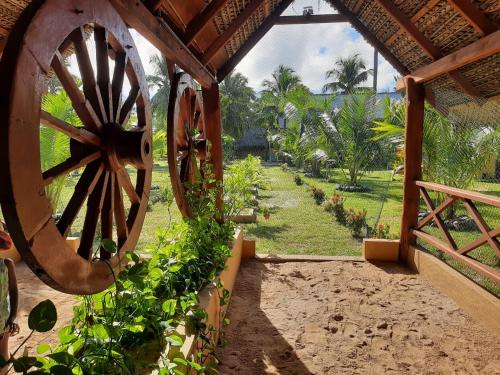 a view of a garden with a wooden wagon wheel at The Tottam Beach Hotel - Trincomalee in Trincomalee