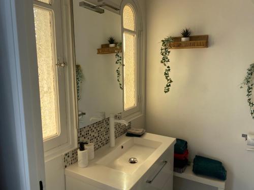 a white bathroom with a sink and a mirror at Villa W in Cassis