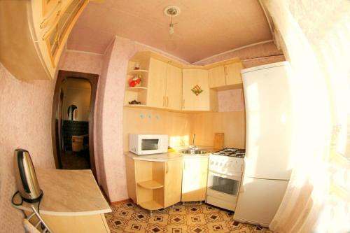 a kitchen with a white refrigerator and a microwave at Dekabrist apartment at petrovsko-zavodskaya 31 in Chita