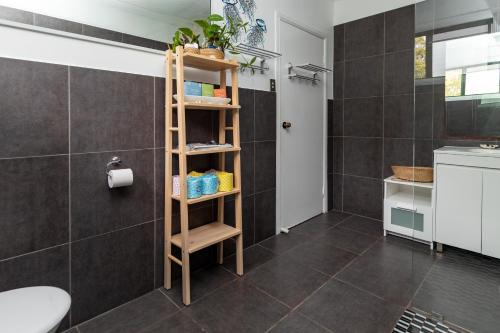 a bathroom with a wooden shelving unit in a bathroom at KiteSurf 1770 Beach House in Agnes Water
