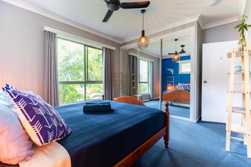 Schlafzimmer mit einem Bett mit blauer Bettwäsche und Kissen in der Unterkunft KiteSurf 1770 Beach House in Agnes Water
