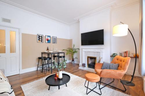 a living room with a couch and a fireplace at Sensational West End Living with Bicocca Stays in Aberdeen