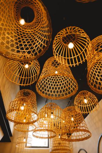a bunch of wicker chandeliers hanging from a ceiling at Comme chez Soye - Private Wellness in Soye