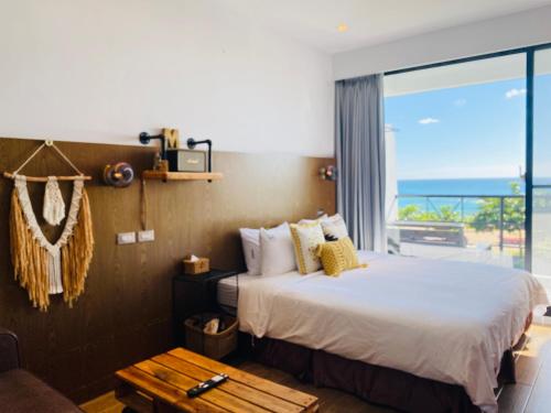 Minimi Inn-Sailrock Beach House في Eluan: غرفة نوم مع سرير وإطلالة على المحيط