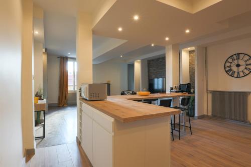a kitchen with a counter and a kitchen island with chairs at Le Fonctionnel - TravelHome in Villefranche-sur-Saône