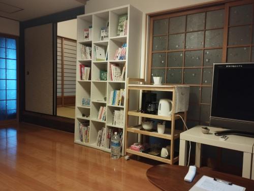 a room with a book shelf filled with books at Kumano Kodo Nagano Guesthouse in Tanabe