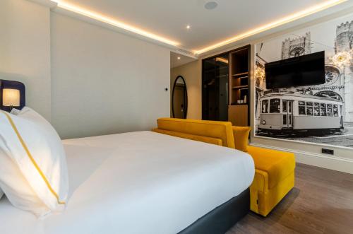 a hotel room with a bed and a couch and a tv at Eurostars Lisboa Baixa in Lisbon