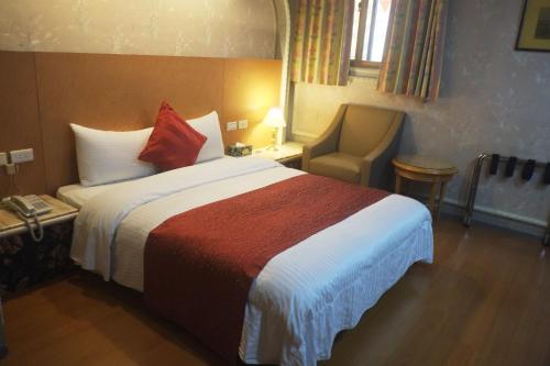台北的住宿－冨粧商旅，酒店客房带一张大床和一把椅子