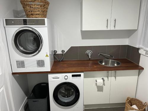 cocina con lavadora y fregadero en Billabong Cottage, en Oxley Island
