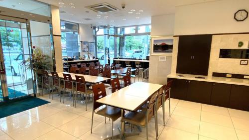 a restaurant with tables and chairs and a clock on the wall at Toyoko Inn Hiroshima Ekimae Ohashi Minami in Hiroshima