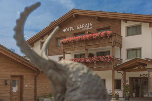 a hotelenna building with a balcony with flowers on it at Hotel Sarain Active Mountain Resort in Lenzerheide