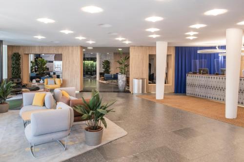 um átrio de escritório com cadeiras e uma recepção em Swissôtel Kursaal Bern em Berna