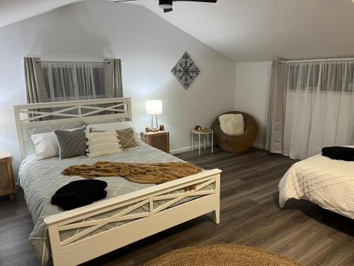 1 dormitorio con 1 cama grande y 1 silla en Billabong Cottage, en Oxley Island