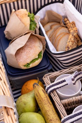 two baskets of food with sandwiches and fruit on a table at Batelo - Adults Only in Benitses
