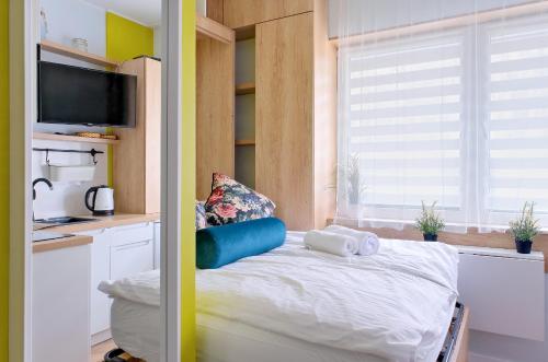 a small bedroom with a bed and a kitchen at Pokój 24E in Sobieszewo