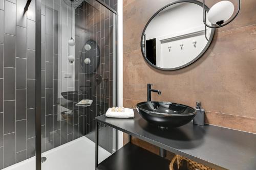 a bathroom with a black sink and a mirror at Downtown Apartments Aura III in Gdańsk